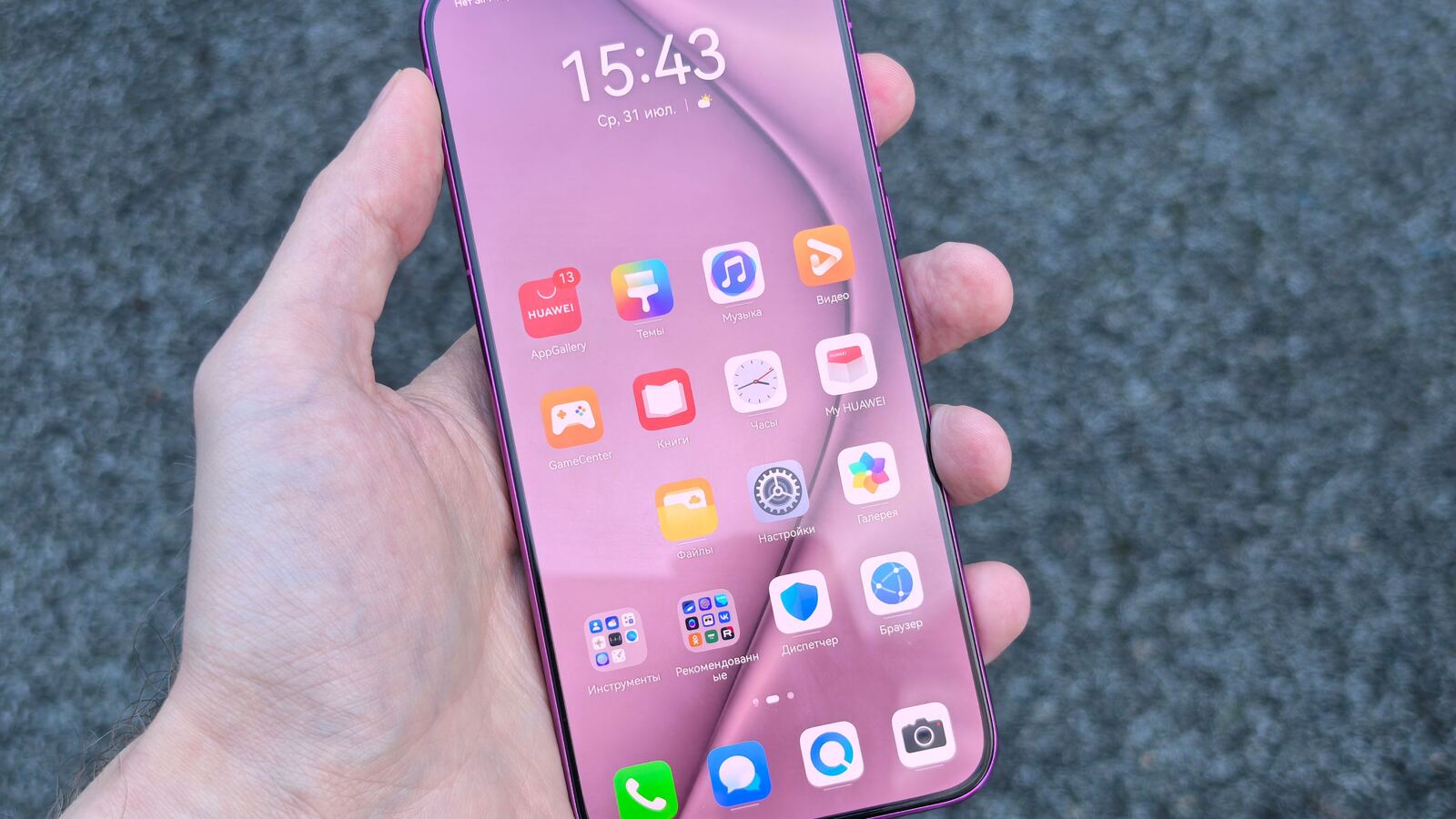 Mão segura um smartphone Android com ícones de aplicações e a AppGallery visível no ecrã.