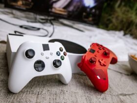 Dois comandos de videojogos junto a uma consola e um televisor
