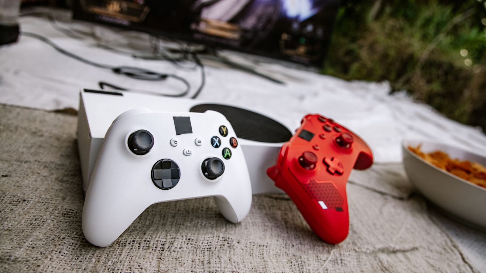 Dois comandos de videojogos junto a uma consola e um televisor