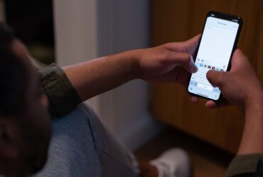 Pessoa segura um iPhone enquanto escreve uma nova mensagem.