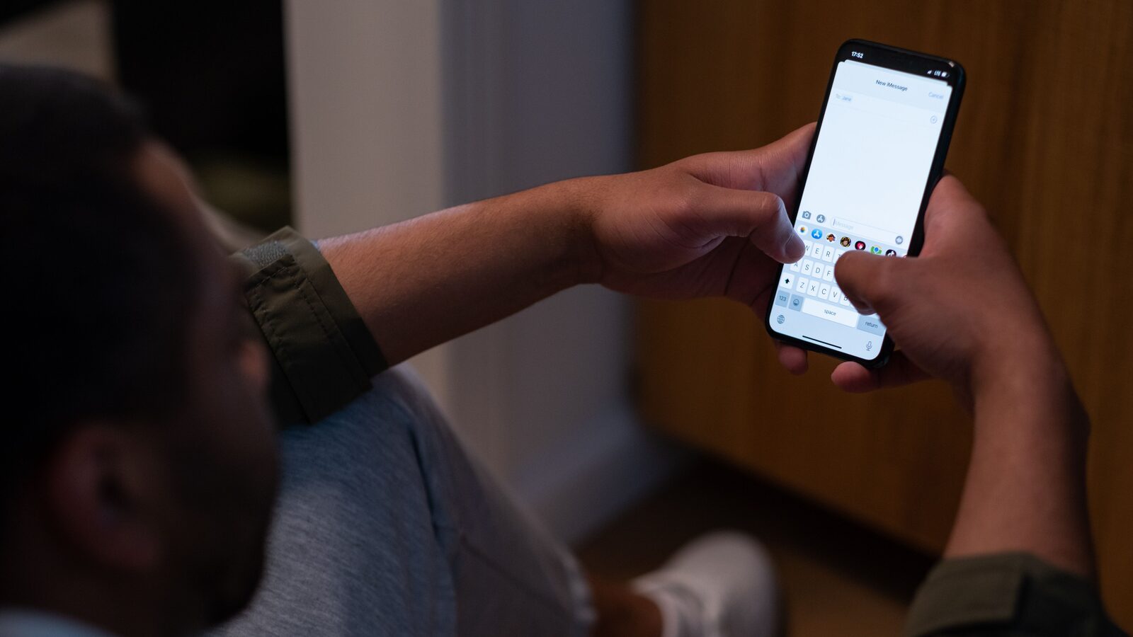 Pessoa segura um iPhone enquanto escreve uma nova mensagem.