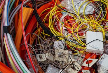 Cabos coloridos e pequenos componentes elétricos reunidos para reciclagem.
