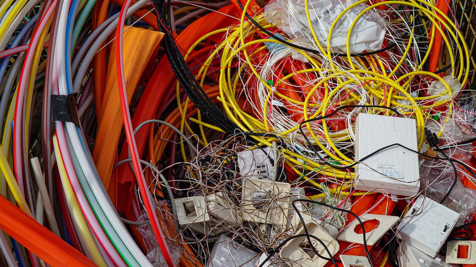 Cabos coloridos e pequenos componentes elétricos reunidos para reciclagem.