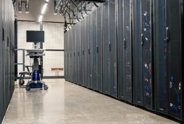 Corredor de um centro de dados com filas de servidores em ambos os lados.