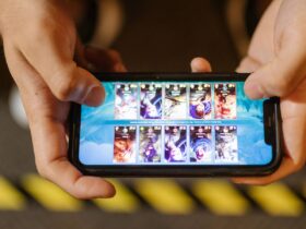 Mãos seguram um smartphone na horizontal durante uma sessão de jogo móvel.