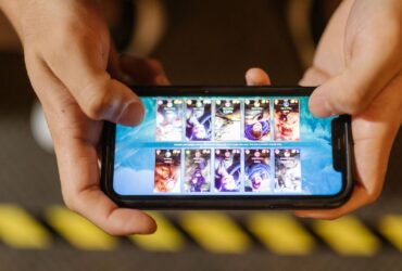 Mãos seguram um smartphone na horizontal durante uma sessão de jogo móvel.
