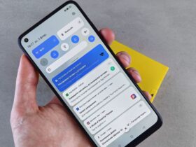 Mão segura um telemóvel Android com o painel de notificações aberto.
