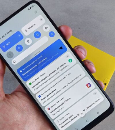 Mão segura um telemóvel Android com o painel de notificações aberto.