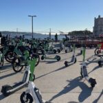 Trotinetes e bicicletas partilhadas estacionadas junto ao rio Tejo, em Lisboa.