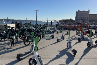 Trotinetes e bicicletas partilhadas estacionadas junto ao rio Tejo, em Lisboa.