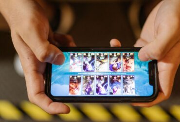 Duas mãos seguram um smartphone na horizontal durante uma partida de um jogo móvel.