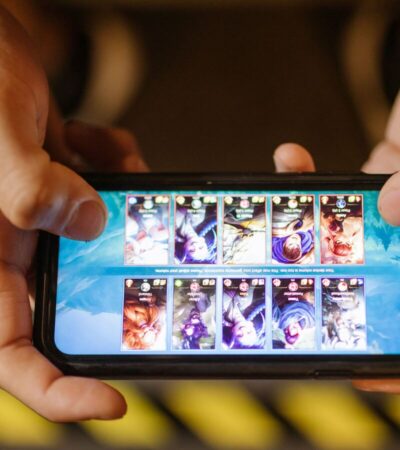 Duas mãos seguram um smartphone na horizontal durante uma partida de um jogo móvel.