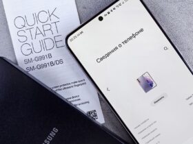 Smartphone Samsung no ecrã de informações do telefone, junto ao guia de início rápido e a uma capa preta