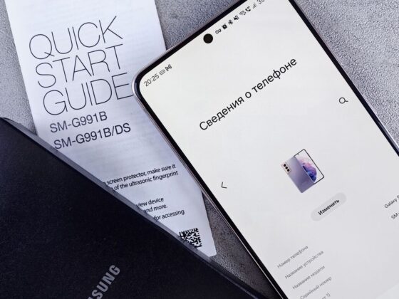 Smartphone Samsung no ecrã de informações do telefone, junto ao guia de início rápido e a uma capa preta