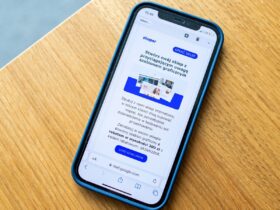 Smartphone sobre mesa de madeira exibindo uma mensagem promocional na tela