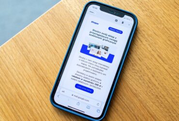 Smartphone sobre mesa de madeira exibindo uma mensagem promocional na tela