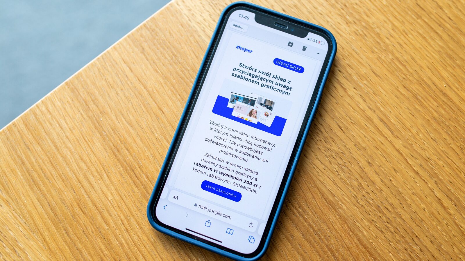Smartphone sobre mesa de madeira exibindo uma mensagem promocional na tela